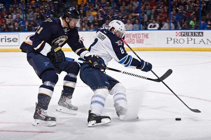 Jacob Trouba #8 of the Winnipeg Jets handles the puck as Patrik Berglund #21 of the St. Louis Blues defends in St. Louis.