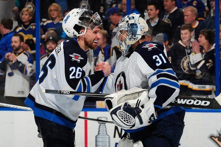 Blake Wheeler #26 and Ondrej Pavelec #31 of the Winnipeg Jets celebrate after defeating the St. Louis Blues on Tuesday at the Scottrade Center in St. Louis.