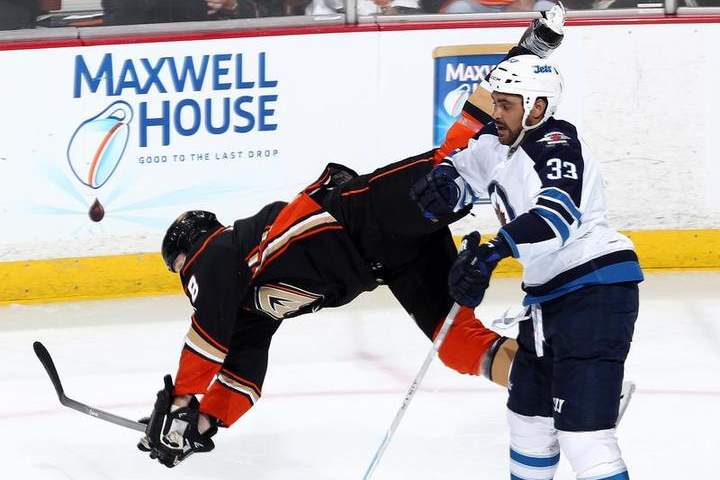 Dustin Byfuglien of the Winnipeg Jets knocks Tim Jackman of the Anaheim Ducks to the ice during the third period in Game One of the Western Conference Quarterfinals during the 2015 NHL Stanley Cup Playoffs.