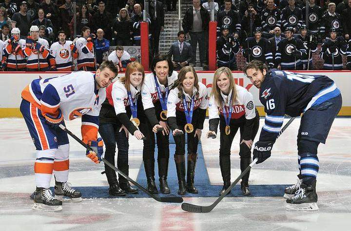 Jill Officer, third from left, drops the puck at a Winnipeg Jets game with teammates Dawn McEwen, to her left, Kaitlyn Lawes, to her right, and skip Jennifer Jones in March.