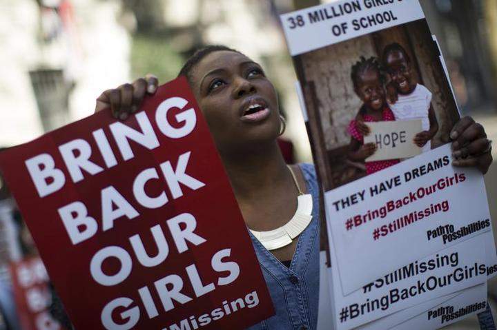 A woman holds a sign as other protesters gather outside Nigeria House to mark the one year anniversary since a group of Nigerian schoolgirls were abducted on April 14, 2015 in London, England.