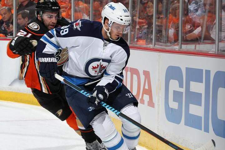 Tobias Enstrom of the Winnipeg Jets controls the puck in front of Kyle Palmieri during the first period of a playoff game on April 16, 2015.