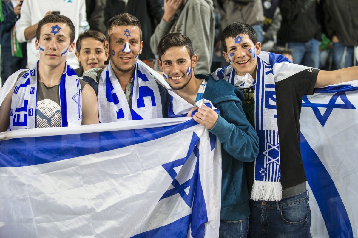 Israel's supporters hold a national flag during the Euro 2016 qualifying football match between Israel and Belgium on March 31, 2015.