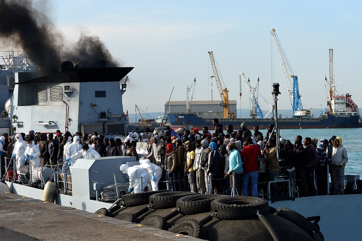 Rescued migrants wait to disembark off the Italian Guardia di Finanza vessel Denaro at the Sicilian harbour of Catania on April 23, 2015. 