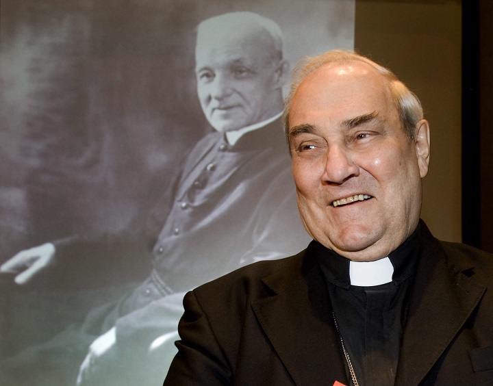 Cardinal Jean-Claude Turcotte stands next to a portrait of Brother André, prior to a news conference in Montreal, Friday, Feb. 19, 2010.