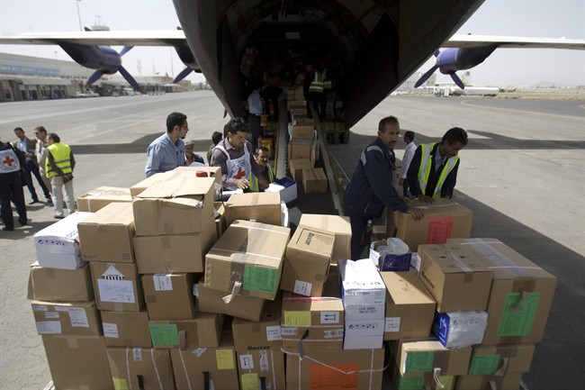 Aid workers unload humanitarian relief supplies for civilians affected by a Saudi-led airstrike campaign from a cargo shipment at the airport in Sanaa, Yemen, Friday, April 10, 2015. 