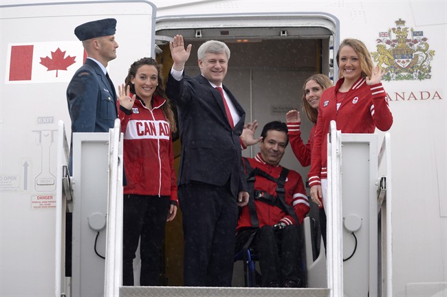 Prime Minister Stephen Harper, centre, accompanied by Canadian Pan Am and Parapan Am athletes waves as he departs for Panama to participate in the Summit of the Americas, in Ottawa on Friday, April 10, 2015.
