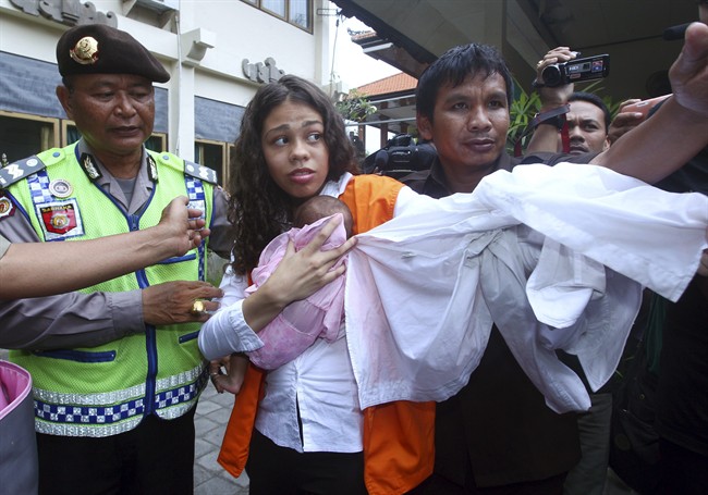 Heather Mack of Chicago, Ill., center, carries her baby daughter as she arrives at the Denpasar District Court before her verdict trial in Bali, Indonesia, Tuesday, April 21, 2015. 
