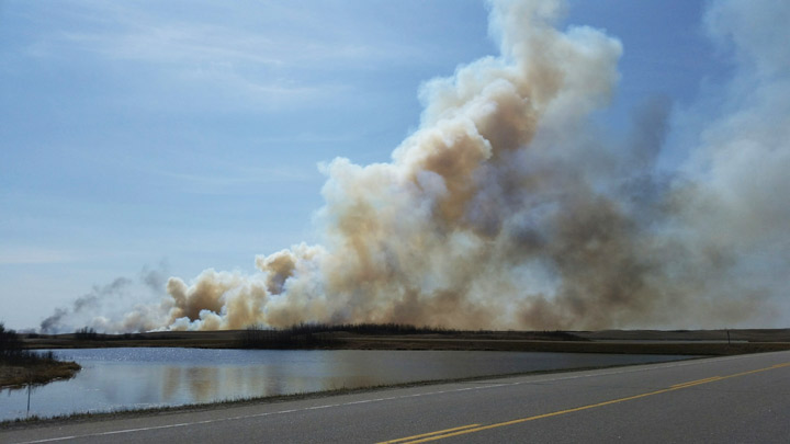 Saskatchewan RCMP say a grass fire has crossed Highway 14 east of Biggar, closing roads in the area