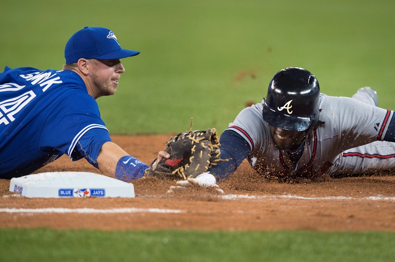 Toronto Blue Jays' Justin Smoak, left, tags out Atlanta Braves' Cameron Maybin to complete an unassisted double play during seventh inning interleague baseball action in Toronto on Sunday, April 19, 2015. 