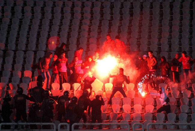 FILE - In this Feb. 1, 2012 file photo, Egyptian fans clash with riot police following an Al-Ahly club soccer match .
