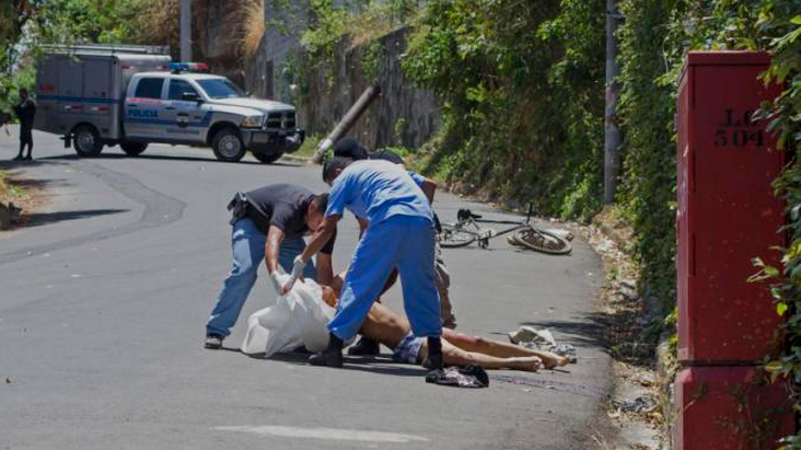 In this April 4, 2015 photo, forensic workers place the body of Luis Ernesto Aquino in a body bag after he was killed by unidentified gunmen in El Cobanal, El Salvador. This Central American country had more homicides in March than any other single month in a decade, a dark moment that some attribute to the collapse of a gang truce and one that could mark a trend of greater violence to come.