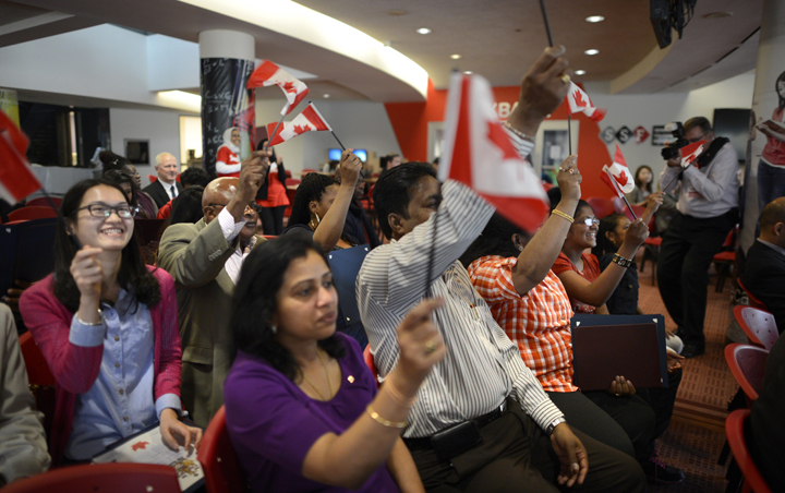 Canadian flags are proudly waved during a citizenship ceremony at Seneca College Markham on Oct 23 2013.