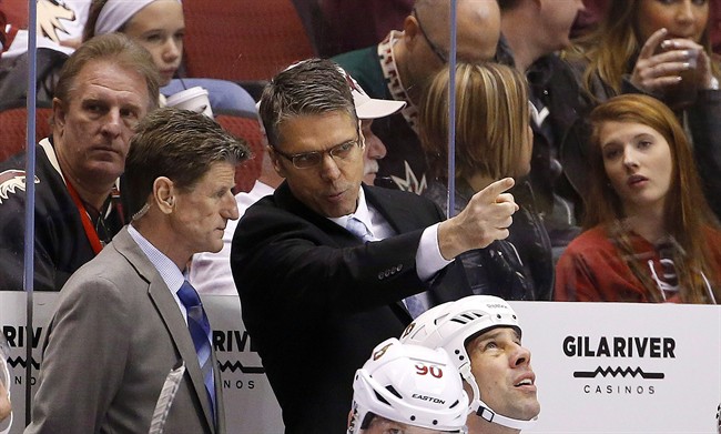 Ottawa Senators head coach Dave Cameron, right, points something out to assistant coach Mark Reeds, left, on the ice during the first period of an NHL hockey game against the Arizona Coyotes in Glendale, Ariz., on Jan. 10, 2015. 