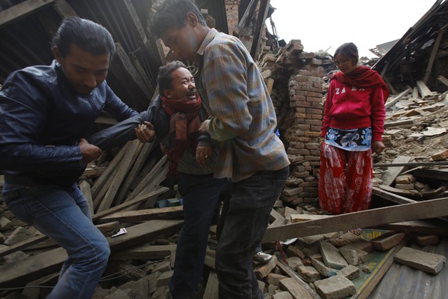 A Nepalese man cries after rescue workers found his mother's body amid earthquake debris in Bhaktapur near Kathmandu, Nepal, Sunday, April 26, 2015.