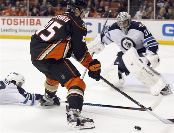 Winnipeg Jets defenceman Tobias Enstrom, left, slides in to knock the puck away from Anaheim Ducks defenceman Sami Vatanen with goalie Ondrej Pavelec defending in January. There's no history of bad blood between the Winnipeg Jets and Anaheim Ducks.