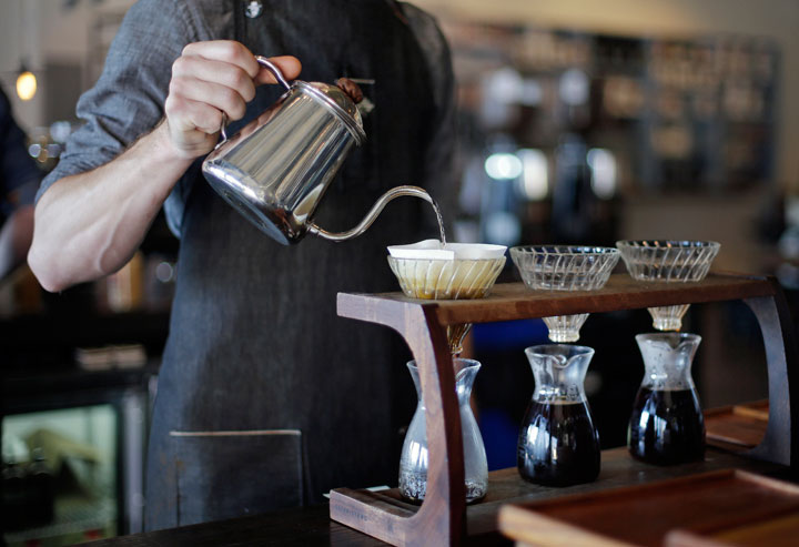 In this April 6, 2015, photo, Jesse Lendzion uses the pour over method for brewing coffee at the Barista Parlor in the East Nashville area of Nashville, Tenn. East Nashville houses an eclectic collection of restaurants, bars, coffee shops, bakeries and stores, mixed into a residential area of 1950s and 1960s homes.