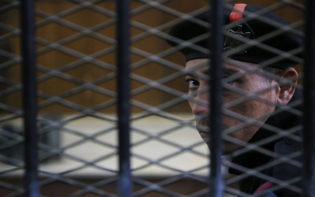 An Egyptian policeman guards the courtroom defendant's cage during the verdict hearing in a case rooted in violence that swept the country after the military-led ouster of Islamist President Mohammed Morsi in 2013.