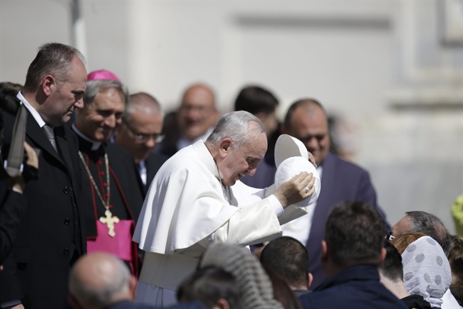 Pope Francis exchanges his skull cap with one donated to him by a pilgrim as he leaves at the end of his weekly general audience, in St. Peter's Square, at the Vatican, Wednesday, April 22, 2015.