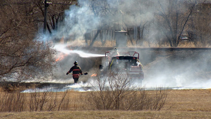 Saskatoon firefighters battle a grass fire at Circle and Airport Drive on April 9, 2015. Warm, dry conditions are creating an ideal situation for grass fires around the city.