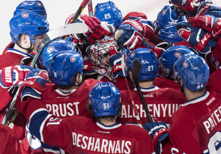 Montreal Canadiens goalie Carey Price is surrounded by teammates following their 4-3 victory over the Detroit Red Wings during overtime in NHL hockey action Thursday, April 9, 2015 in Montreal. Price broke a team record with 43 wins for a goaltender.