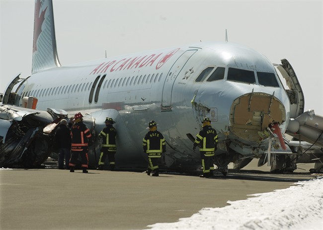 Transportation Safety Board investigators and airport firefighters work at the crash site of Air Canada AC624 at Stanfield International Airport in Halifax on Monday, March 30, 2015. The flight crashed during a snowstorm Sunday, March 29, 2015. Transport Canada lawyers are in a Halifax courtroom Monday, Dec. 12, 2016, challenging certification of a class action lawsuit filed on behalf of the 133 passengers.