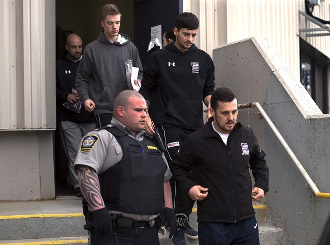 Darren Smalley, Craig Stoner, Joshua Finbow and Simon Radford, left to right, members of the British navy in Nova Scotia for a hockey tournament, are released from provincial court in Dartmouth, N.S. on Monday, April 20, 2015. 