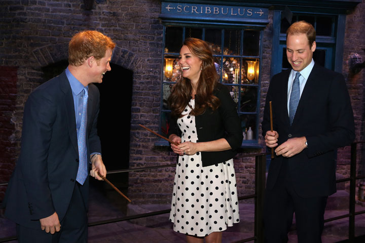 Prince Harry, Catherine, Duchess of Cambridge and Prince William, Duke of Cambridge laugh as they hold wands on the set used to depict Diagon Alley in the Harry Potter Films during the Inauguration Of Warner Bros. Studios Leavesden on April 26, 2013 in London, England.