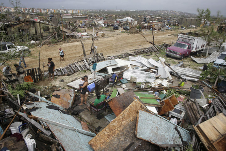 A people salvage useful remains from homes destroyed by Hurricane Odile in Los Cabos, Mexico on Sept. 15, 2014. The names Odile and Isis have been retired from a list of tropical storm names, but for much different reasons.