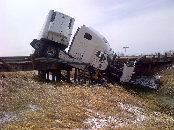Highway 15 just east of Winnipeg was closed Tuesday after a tractor-trailer crashed and was left hanging over a bridge.