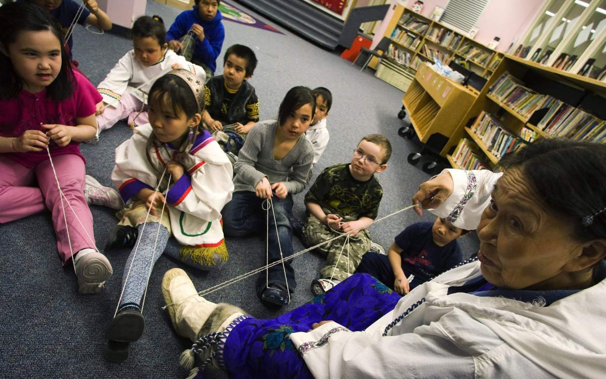 Inuktitut elder Siipa Isullatak teaches children how to sew, at the Nakasuk Elementary School in Iqaluit, Nunavut on Wednesday, April 1, 2009.