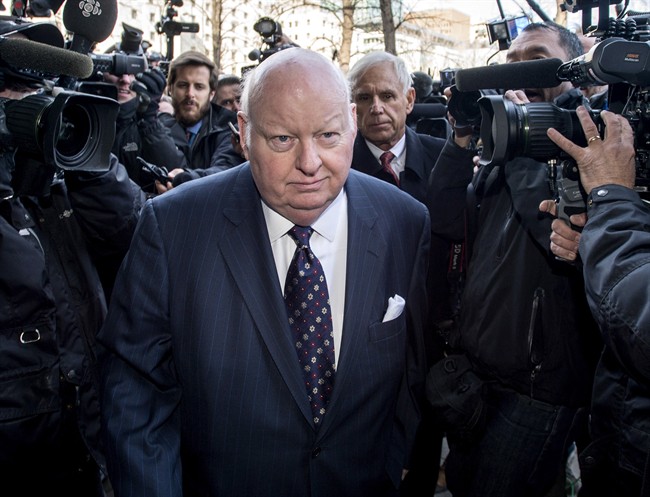 Suspended senator Mike Duffy, left, is followed by his lawyer Donald Bayne as he arrives at the courthouse for his first court appearance in Ottawa on Tuesday, April 7, 2015.