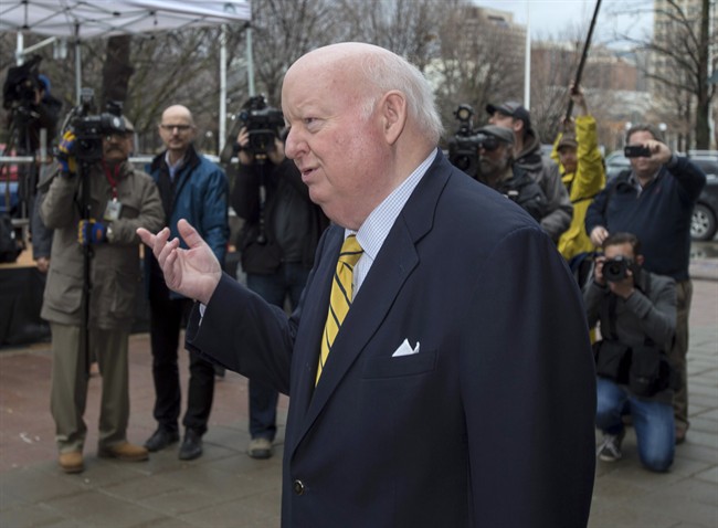 Suspended senator Mike Duffy speaks to his wife Heather (not shown) as they wait to be picked up after leaving the courthouse in Ottawa on Friday, April 10, 2015.
