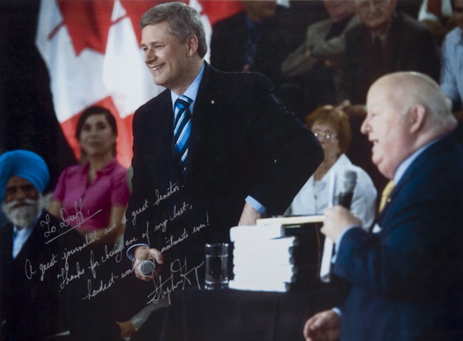 A signed PMO photo of Prime Minister Stephen Harper with suspended former Conservative Senator Mike Duffy, an exhibit of the defence, is shown at the trial of Mike Duffy on Thursday, April 9, 2015. THE CANADIAN PRESS/Hand Out