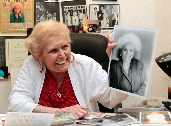 In this July, 18, 2011, file photo, Jean Nidetch, founder of Weight Watchers, holds up a photo of herself at her home in Parkland, Fla. 