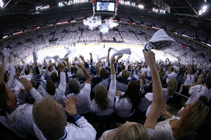 Winnipeg Jets fans celebrate a first period goal against the Anaheim Ducks during game three NHL playoff hockey action in Winnipeg, Monday, April 20, 2015. 