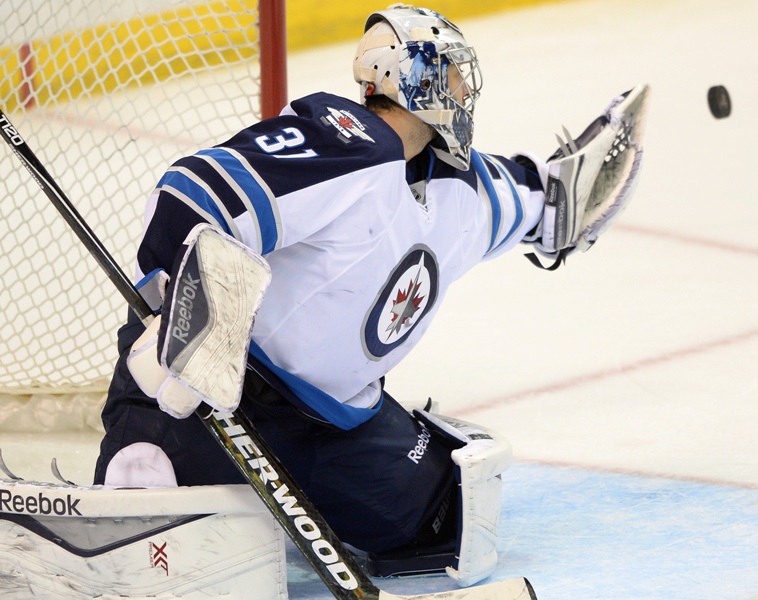 Winnipeg Jets' goalie Ondrej Pavelec (31), of Czech Republic, makes a glove save against the St. Louis Blues during the third period of an NHL hockey game, Tuesday, April 7, 2015, in St. Louis. 