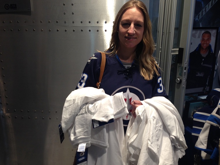 Jody Travassos waits to buy 12 “Our team, our tradition” shirts. Five for her, seven for a stranger who gave him her credit card