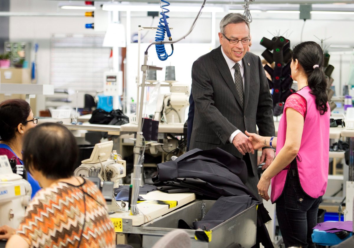 Finance Minister Joe Oliver, centre, greets employees at Canada Goose before speaking to the media, where he announced the date of the federal budget, in Toronto on Thursday, April 2, 2015.