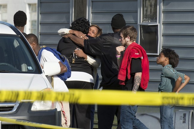 Onlookers gather outside of a house, where police say seven children and one adult have been found dead Monday, April 6, 2015, in Princess Anne, Md. 