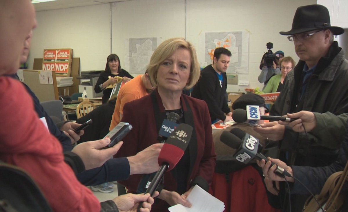 Alberta NDP leader Rachel Notley speaking to reporters at a riding office while campaign volunteers worked behind her preparing candidate lawn signs. April 6, 2015.