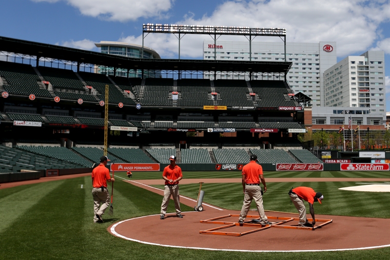 The grounds crew prepares the field before the Baltimore Orioles play the Chicago White Sox at an empty Oriole Park at Camden Yards on April 29, 2015 in Baltimore, Maryland.