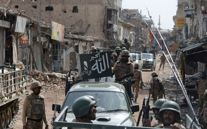 This photograph taken on July 9, 2014 shows Pakistani soldiers patrol through a destroyed bazaar during a military operation against Taliban militants, in the main town of Miranshah in North Waziristan. 