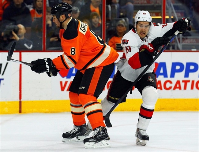 Ottawa Senators' Mark Stone, right, cuts behind Philadelphia Flyers defenseman Nicklas Grossmann in the first period of an NHL hockey game, Saturday, April 11, 2015.