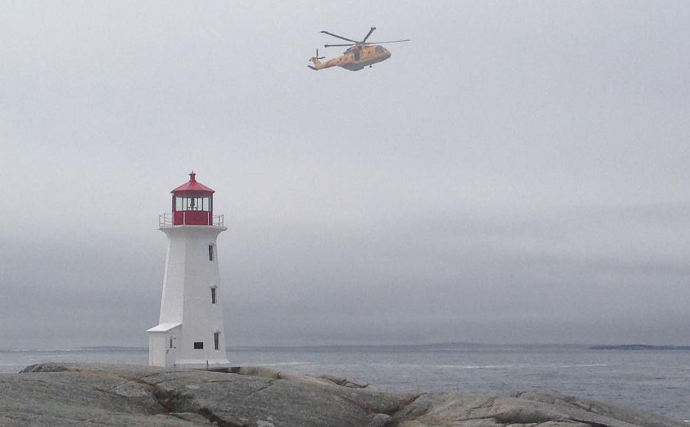 A helicopter flies over Peggys Cove, N.S. as part of search and rescue operations on April 22, 2015.