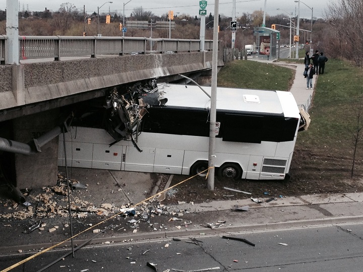 A coach bus is wedged underneath an overpass on Weston Rd. at Albion Rd. on April 27, 2015.
