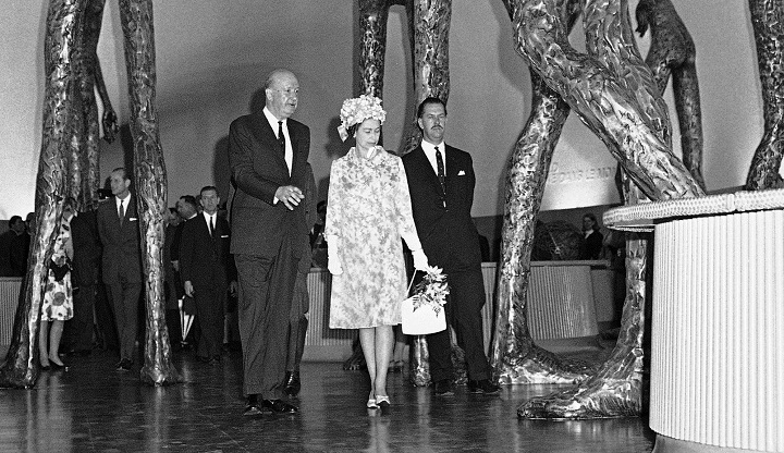 Queen Elizabeth II is dwarfed by tall figures called "Britain in the World" at the British Pavilion at Expo 67 in Montreal, Canada, July 3, 1967, during her tour of Canada.