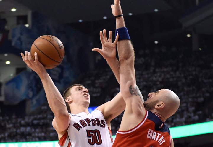 Toronto Raptors’ Tyler Hansbrough (50) commits an offensive foul against Washington Wizards’ Marcin Gortar (4) during the first half in Game 1 of the NBA basketball playoffs in Toronto, Saturday, April 18, 2015.