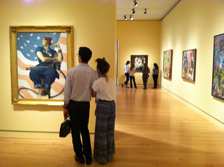 This Sept. 27, 2014 photo shows visitors admiring Norman Rockwell's "Rosie the Riveter" at Crystal Bridges Museum of American Art in Bentonville, Ark.