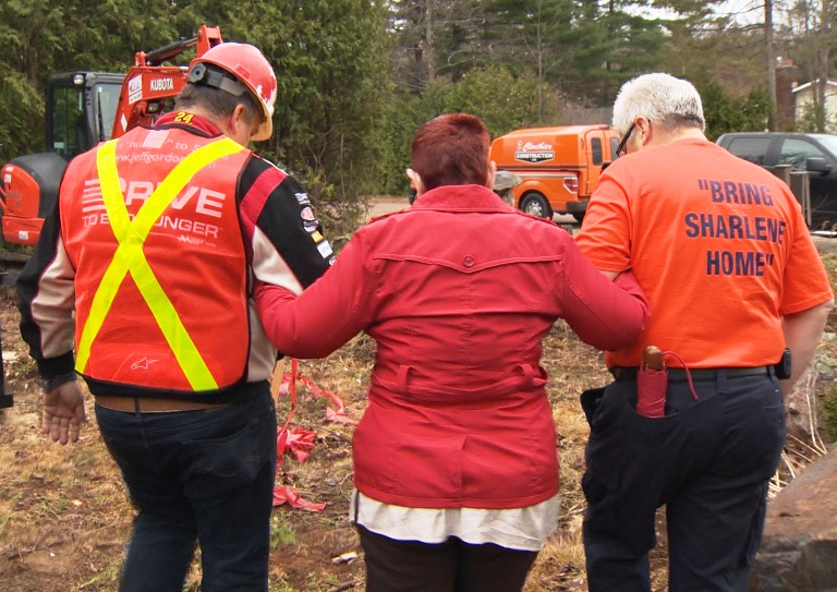 Ted Kent and Doug Liot guide Sharlene Pietersma the flat area of land to do the groundbreaking.